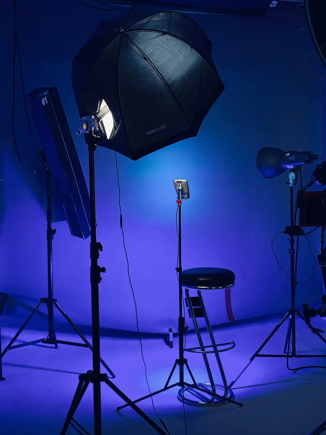 Studio-Setup mit blauem Hintergrund, Lichtformern und Stativ